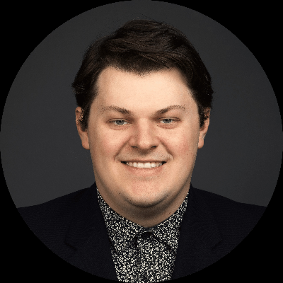 Professional headshot of a smiling man in a dark suit and patterned shirt, representing business professionals in Sacramento, CA.