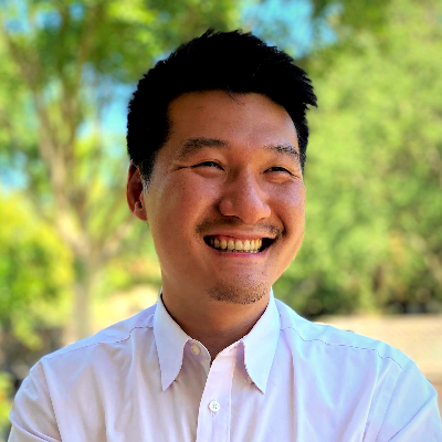 Smiling man in a white shirt outdoors, representing Anew Lending's commitment to personal service in residential mortgages.